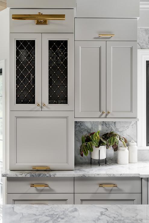 https://www.jennasuedesign.com/wp-content/uploads/2022/05/brass-picture-light-over-light-gray-kitchen-cabinets-1.jpg