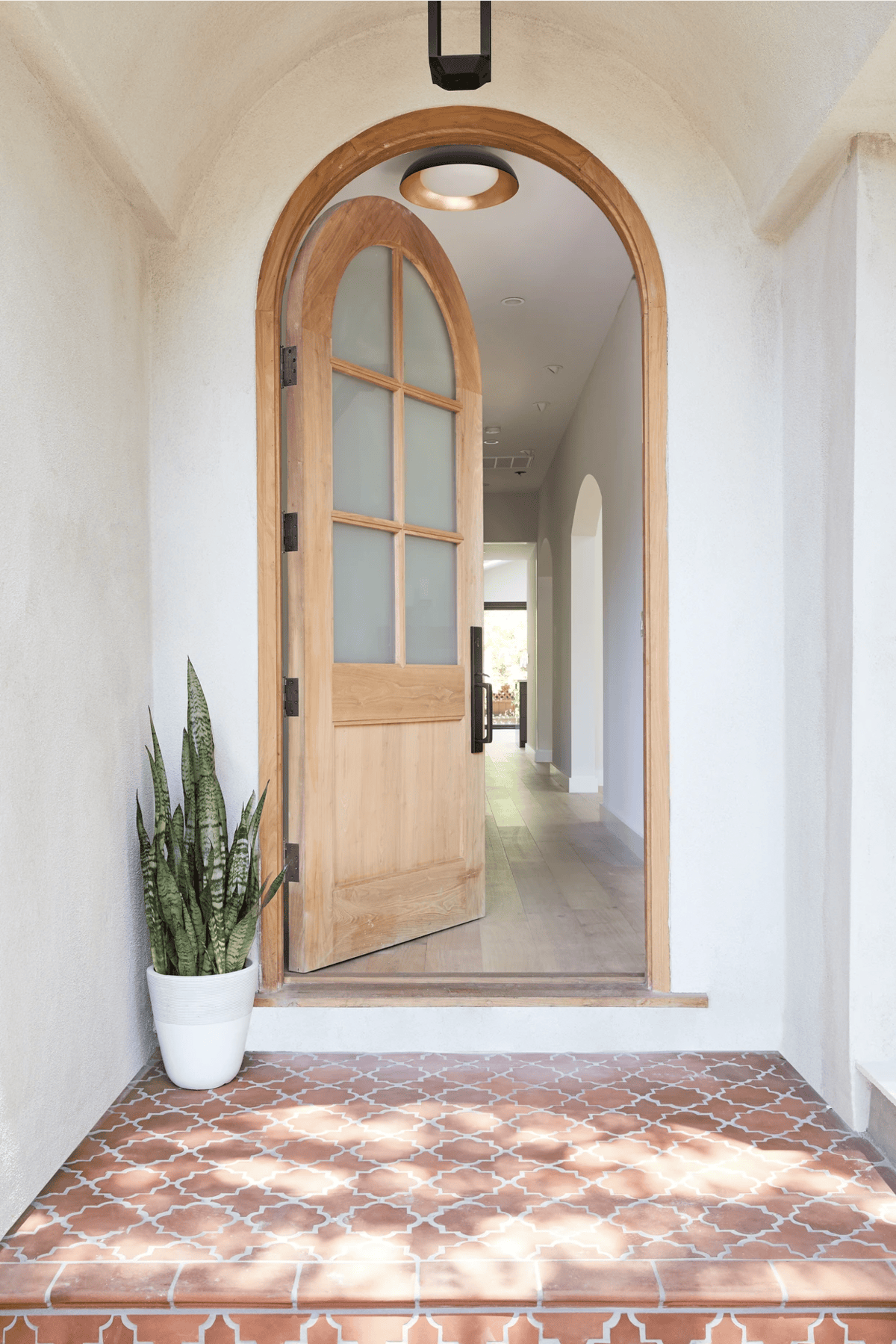 spanish style porch with arched front door and terracotta tile