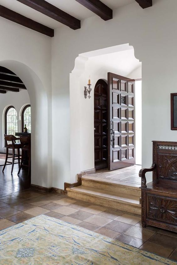 spanish style entrance with dark wood door and archway