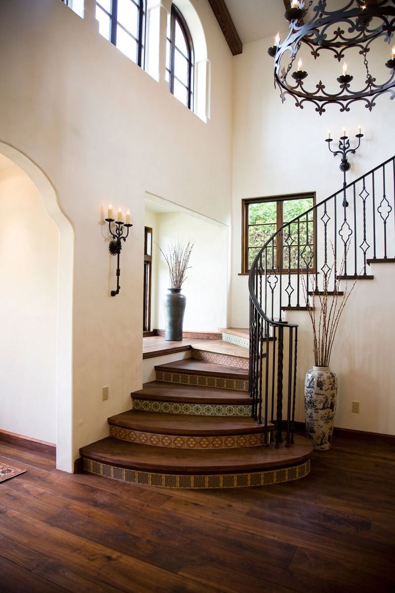 spanish style foyer with curved wood and iron railing staircase