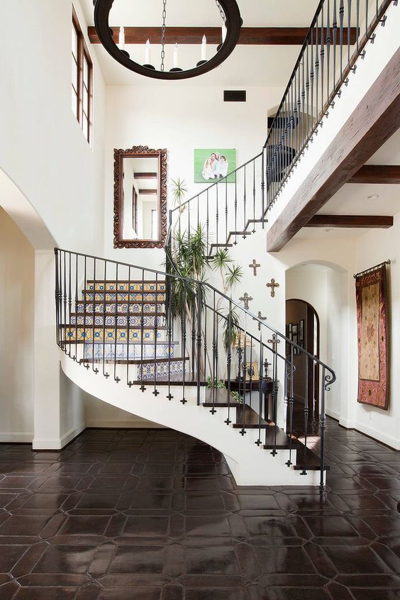 spanish style foyer with curved iron staircase and terracotta tile