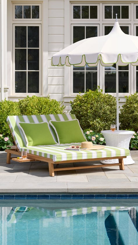 striped cabana chaise lounge by the pool